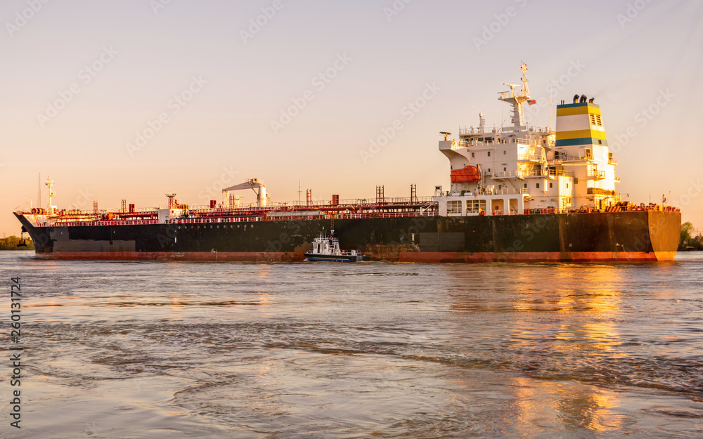 A big ship is traveling at Mississippi River under sunset