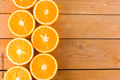 Oranges fruit on wooden boards. Halves of juicy orange on wooden background. Orange fruit, citrus minimal concept. Top view, copy space