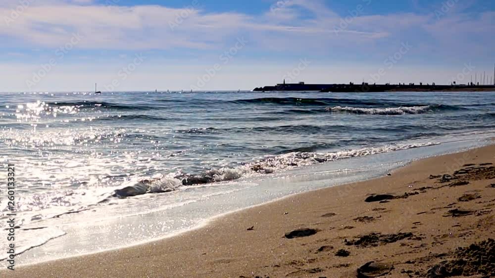 Mediterranean beach waves on beach at eavning time , sunlight reflect on water surface. Fuengirola, Spain. Mediterranean beach waves on beach at eavning time , sunlight reflect on water surface. Fuengirola, Spain.