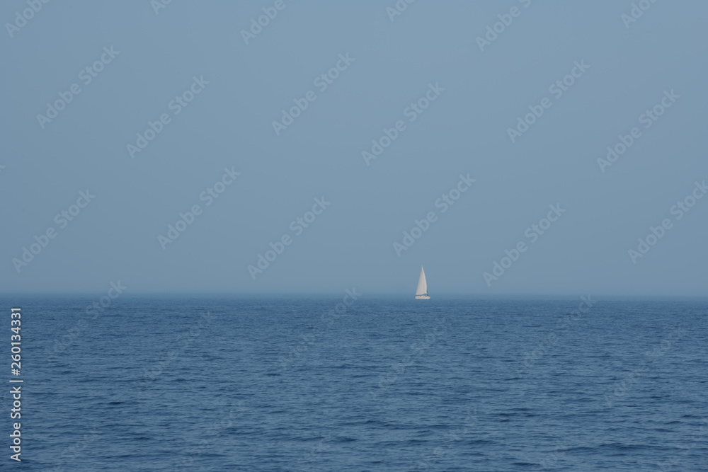 Single white sailboat in blue sea, minimalism