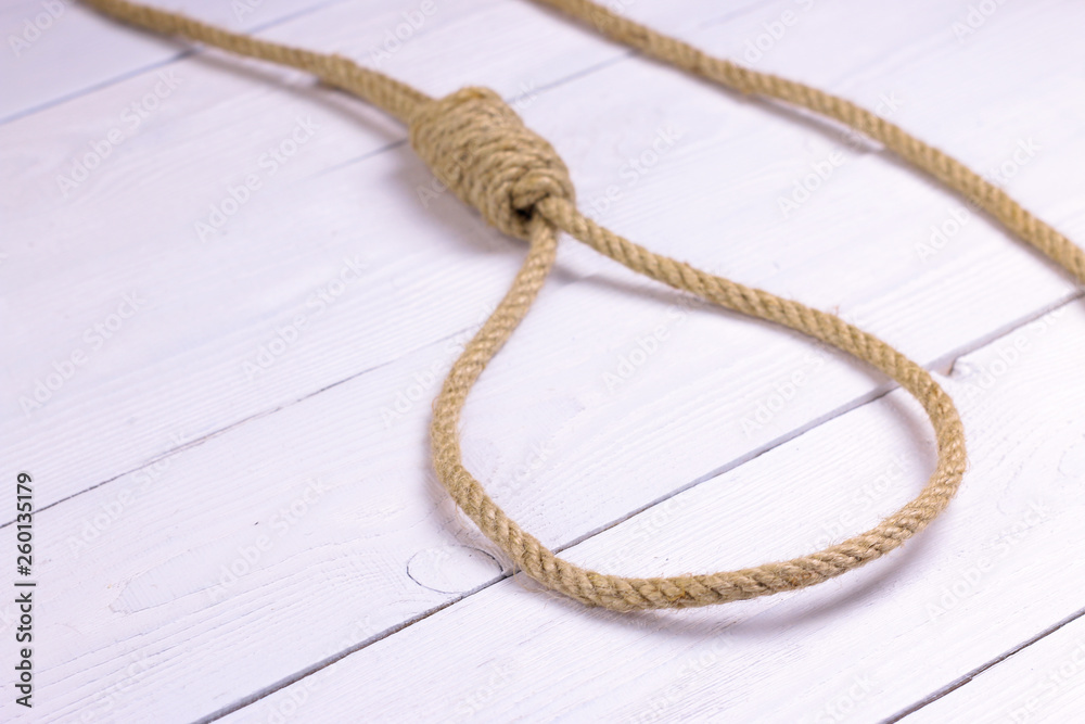 Obraz premium Hanging noose. Rope with loop. Rope with knot and loop on white wooden background.