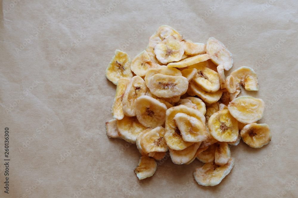 Healthy banana chips on white background. Image with copy space, top view.