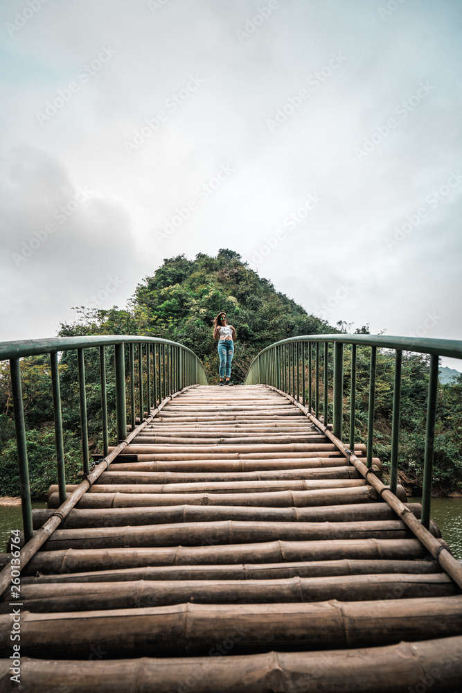 Fototapeta premium Attractive woman posing on a bridge in the mountains of northern Vietnam