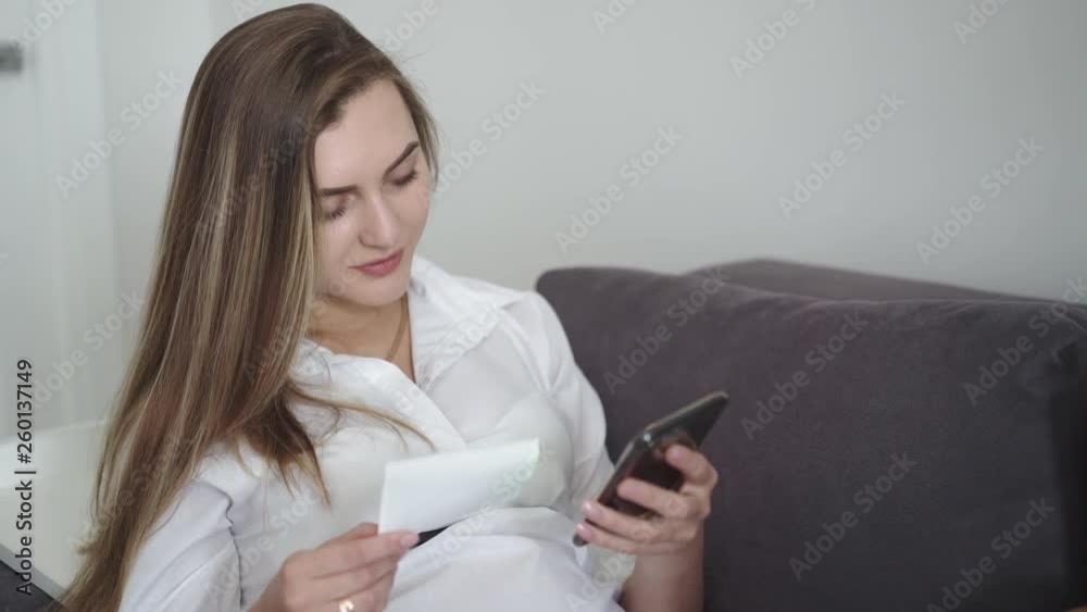Happy pregnant woman holds ultra diagnostic snapshot and using phone Happy pregnant woman holds ultra diagnostic snapshot and using phone
