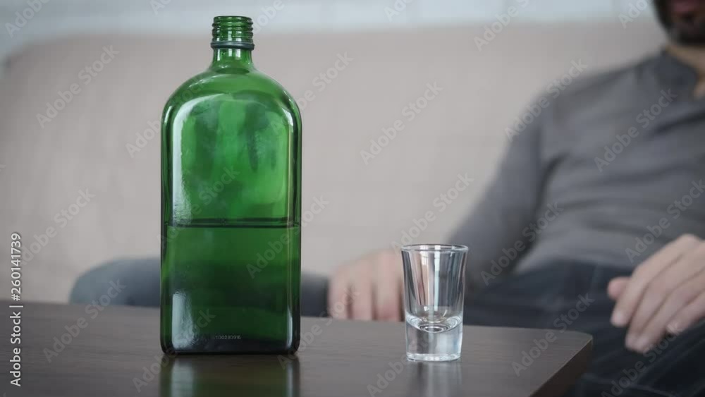 Alcoholism in the family. A woman throws a wedding ring into a glass, a man pours alcohol and drinks. Alcoholism in the family. A woman throws a wedding ring into a glass, a man pours alcohol and drinks.