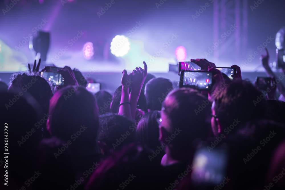 many people who dance and record with the phones at the live music concert many people who dance and record with the phones at the live music concert