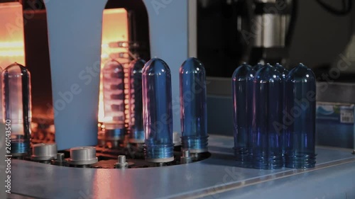 PET preforms move on heating oven line in fast speed. Plastic bottles production