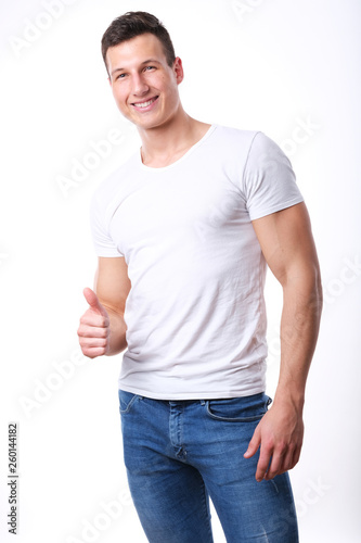Studio shoot of young sport man in white shirt and jeans. 