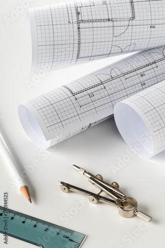 Rolls of architectural blueprint house building plans on white table background