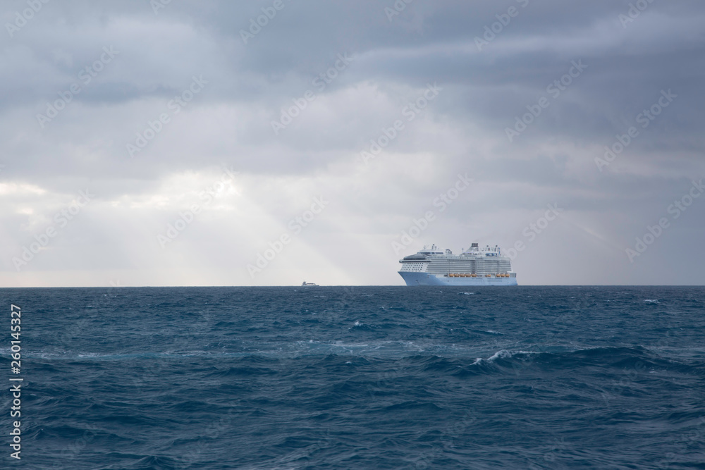 Cloudy skies and cruise ship on turbulent water