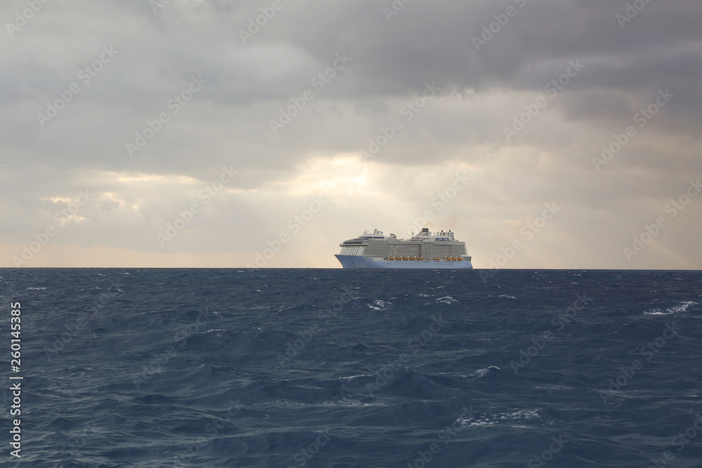 Cloudy skies and cruise ship on turbulent water