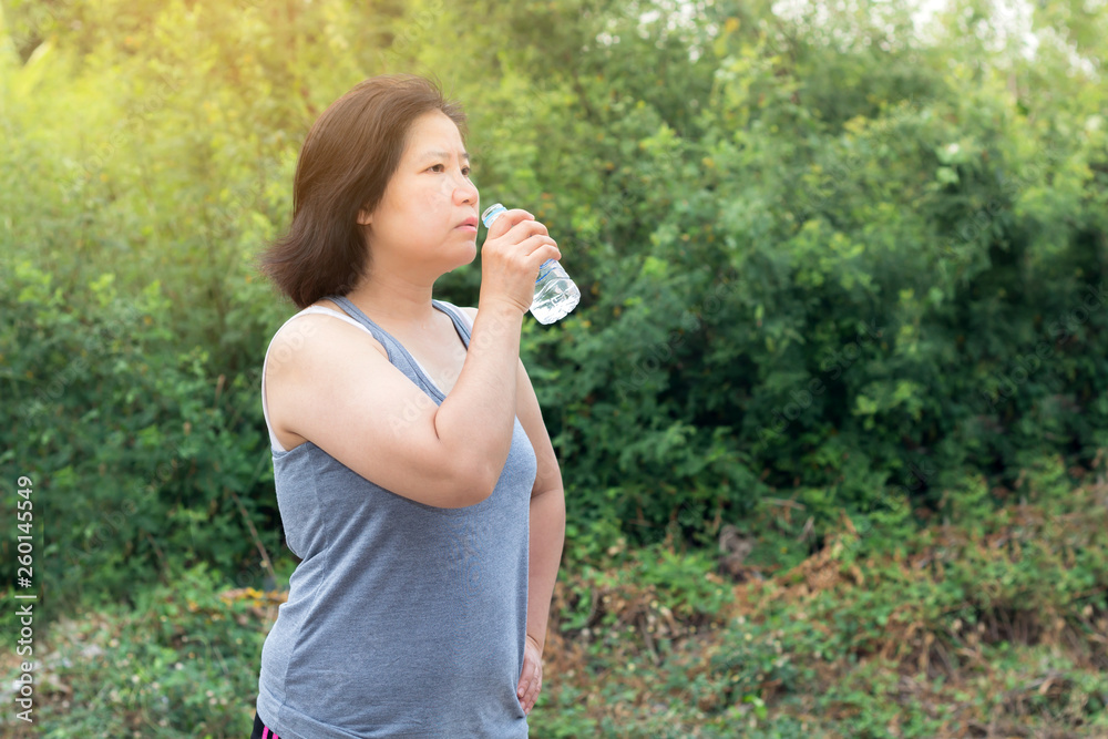 Asian woman drinking water after sport exercise,sport woman holding bottle of pure water