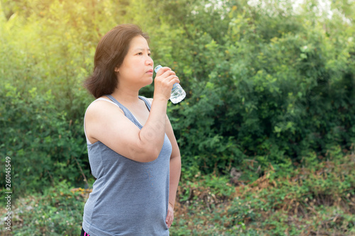 Asian woman drinking water after sport exercise,sport woman holding bottle of pure water