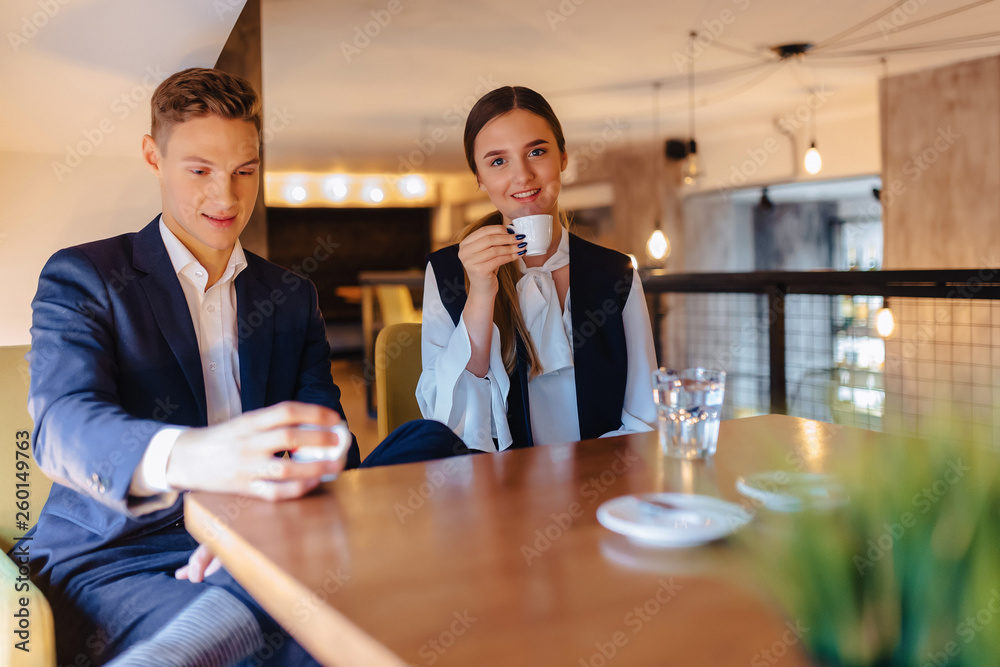 A stylish couple drinks morning coffee at the cafe, young businessmen and freelancers A stylish couple drinks morning coffee at the cafe, young businessmen and freelancers