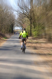 Cyclist rides along the park alley, artistically blurred image, speed lines
