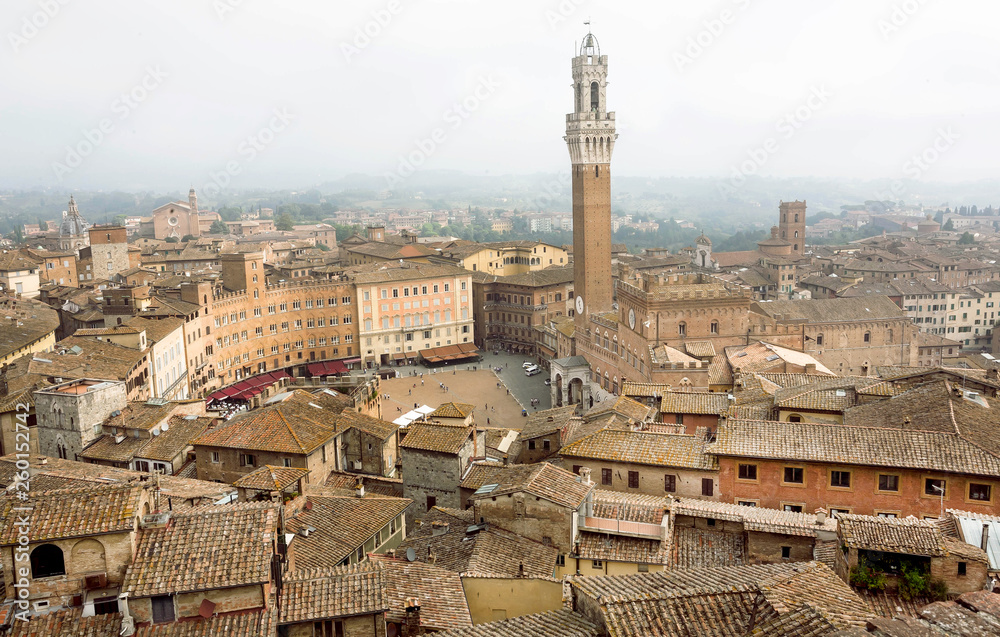 Cityscape of Siena, Tuscany. Tile roofs and 14th century tower Torre del Mangia, Italy. UNESCO World Heritage Site