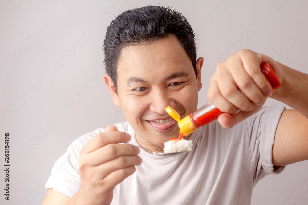 Asian Man Eating Rice with Sambal Chili Sauce Asian Man Eating Rice with Sambal Chili Sauce