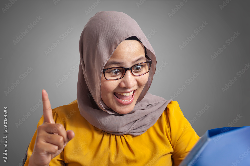 Muslim Businesswoman Working on Laptop at the Office, Thinking Gesture Muslim Businesswoman Working on Laptop at the Office, Thinking Gesture