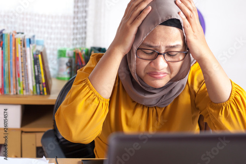 Muslim Businesswoman Working on Laptop at the Office, Tired Stress Headache Gesture