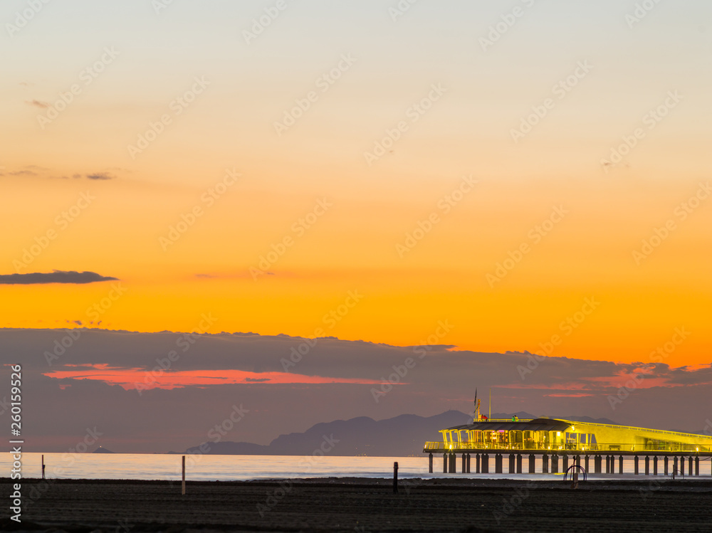 Beach in Tuscany,Lido di Camaiore's new pier at sunset. Italy.