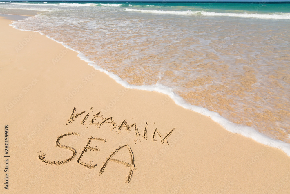 Inscription VITAMIN SEA on sandy beach Inscription VITAMIN SEA on sandy beach