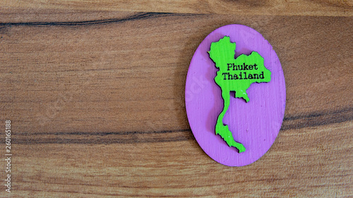 Souvenir or fridge magnet from Thailand on wooden background