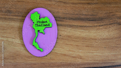 Souvenir or fridge magnet from Thailand on wooden background