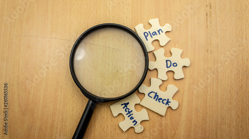Wooden jigsaw puzzle with text Plan,Do,Check,Action (PDCA Cycle). Quality improvement in business concept.