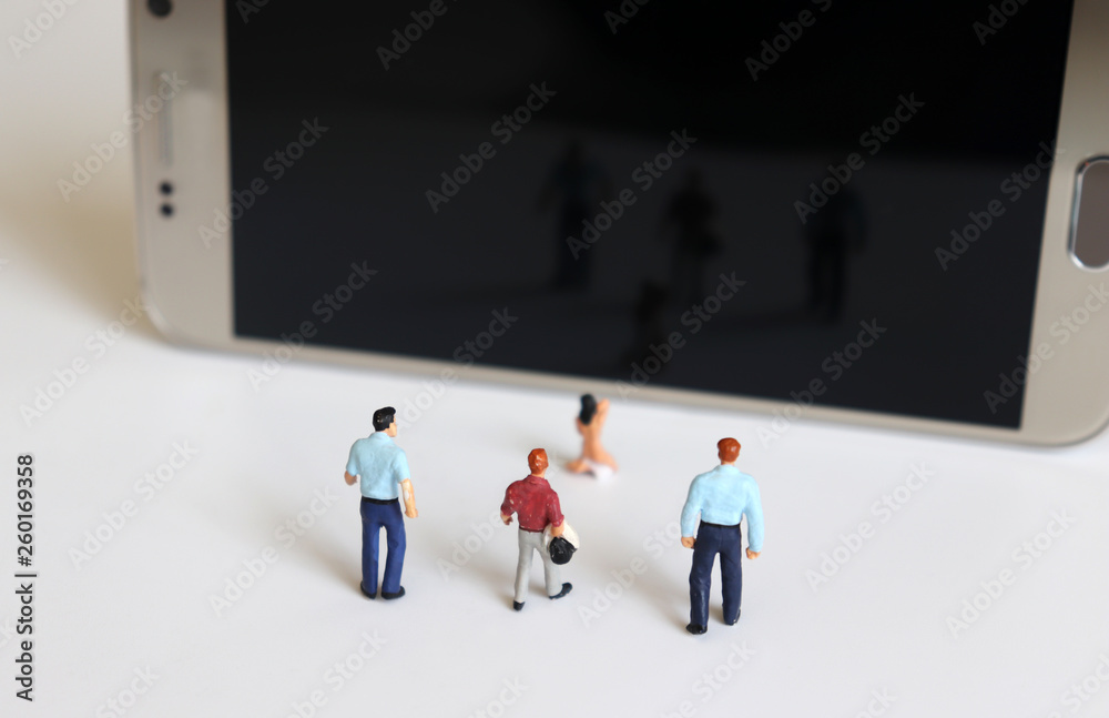 Smartphone and miniature people. Smartphone and miniature people. The concept of illegal video.