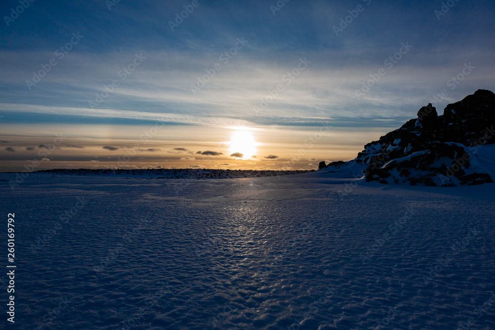 Sunset over the ice and snow in a cold winter landscape