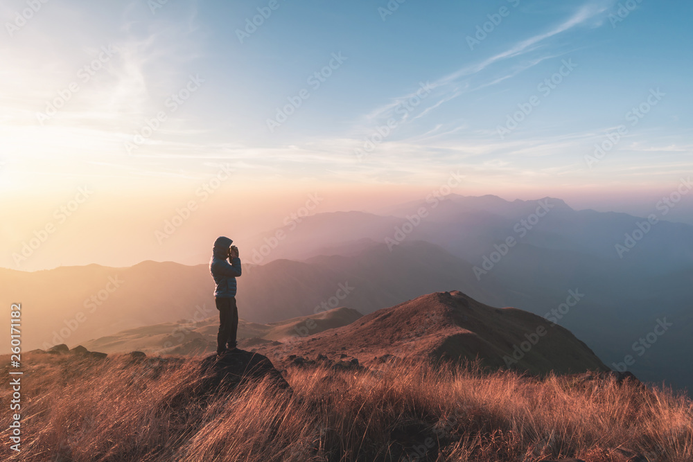 Young man traveler looking beautiful landscape at sunset on mountain, Adventure travel lifestyle concept