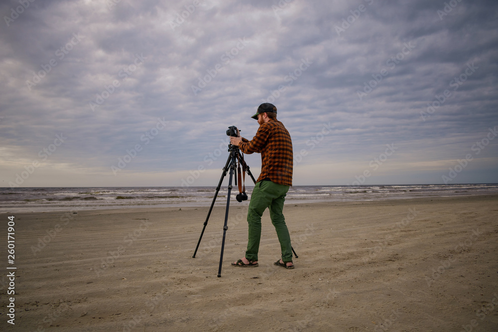 Beach Photographer Using a Tripod to Shoot Waves and Bay Sky