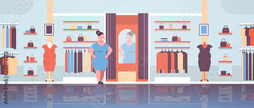 fat obese woman trying on new dress overweight girl looking at mirror fashion boutique shop clothes market modern shopping mall interior horizontal full length
