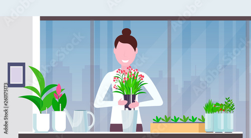 cute girl housewife transplanting plant into new pot happy woman taking care of flower modern home apartment interior gardening concept portrait horizontal