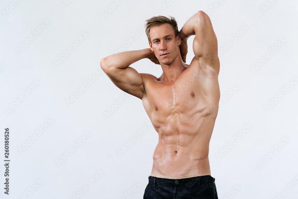 Sexy athletic man with naked torso on white background. Fashion portrait of sporty healthy guy