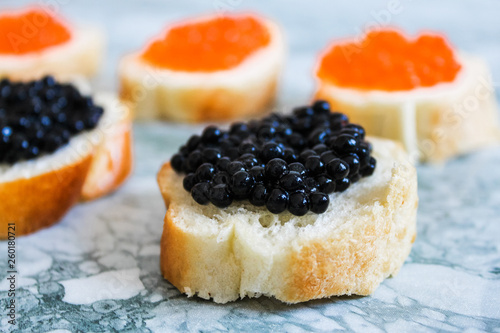 Top view of Tasty Sandwich with black caviar on White marble background.  .Free space for text. Black caviar. Luxurious culinary delicacy.