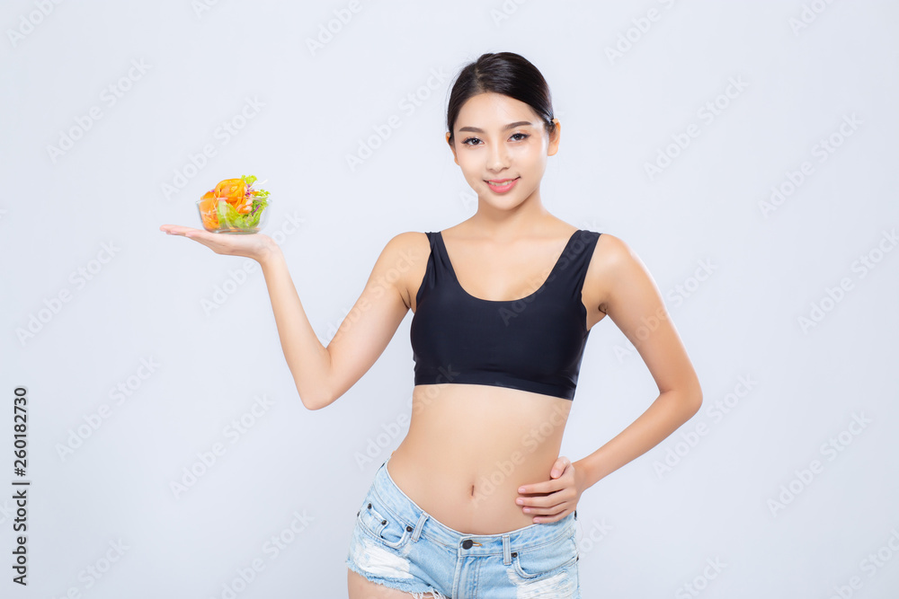 Beautiful portrait young asian woman smiling holding salad vegetable food isolated on white background, girl diet eating vegetarian for healthy, health care or wellness concept.