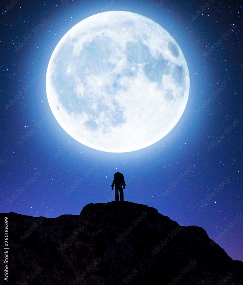 Astronaut on top of a mountain peak with big moon,3d rendering