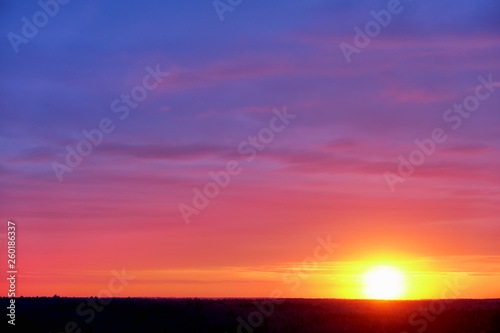 natural color of sky and forest with sunset sun above forest horizon nature background rural scenery landscape on spring time with beautiful sunrise light transition from blue to red and yellow