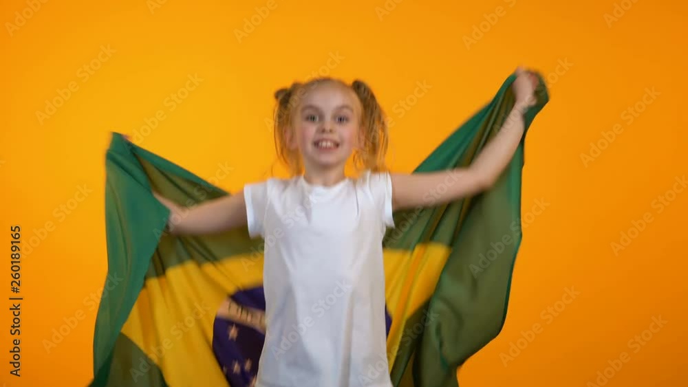 Adorable preteen girl jumping with brazilian flag cheering for favorite team Adorable preteen girl jumping with brazilian flag cheering for favorite team