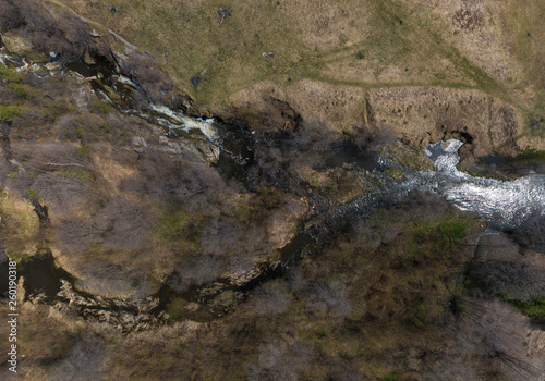 Aerial shot of Gileva village, river and small waterfall. Sunny, spring