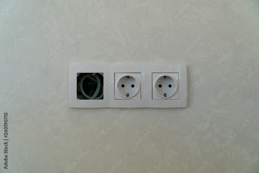 Two Power and free sockets with frame on white wall as a background Two Power and free sockets with frame on white wall as a background