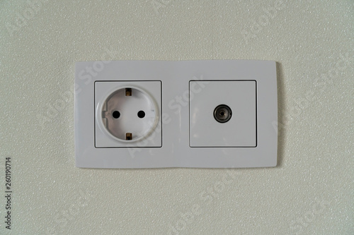Power and tv sockets with frame on white wall as a background