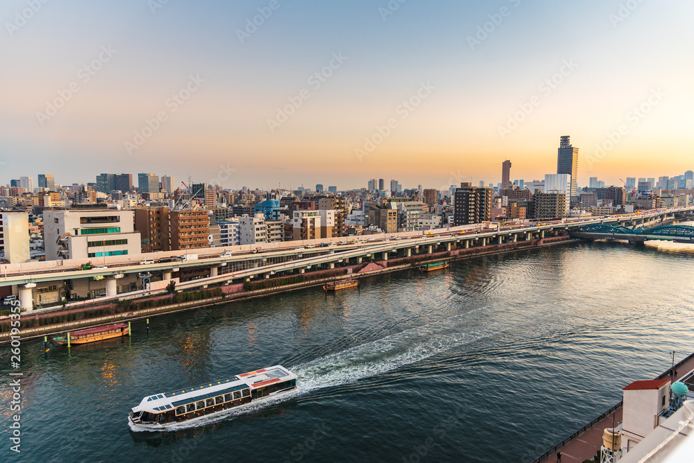Sumida river with a cruise ship at sunset in Asakusa district Tokyo city, Japan.