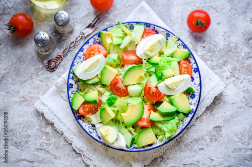 Salad of avocado, fresh cucumbers, cherry tomatoes, quail eggs and lettuce.