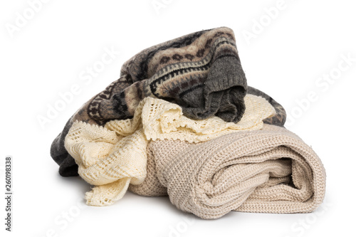 Stack of various sweaters on white background.