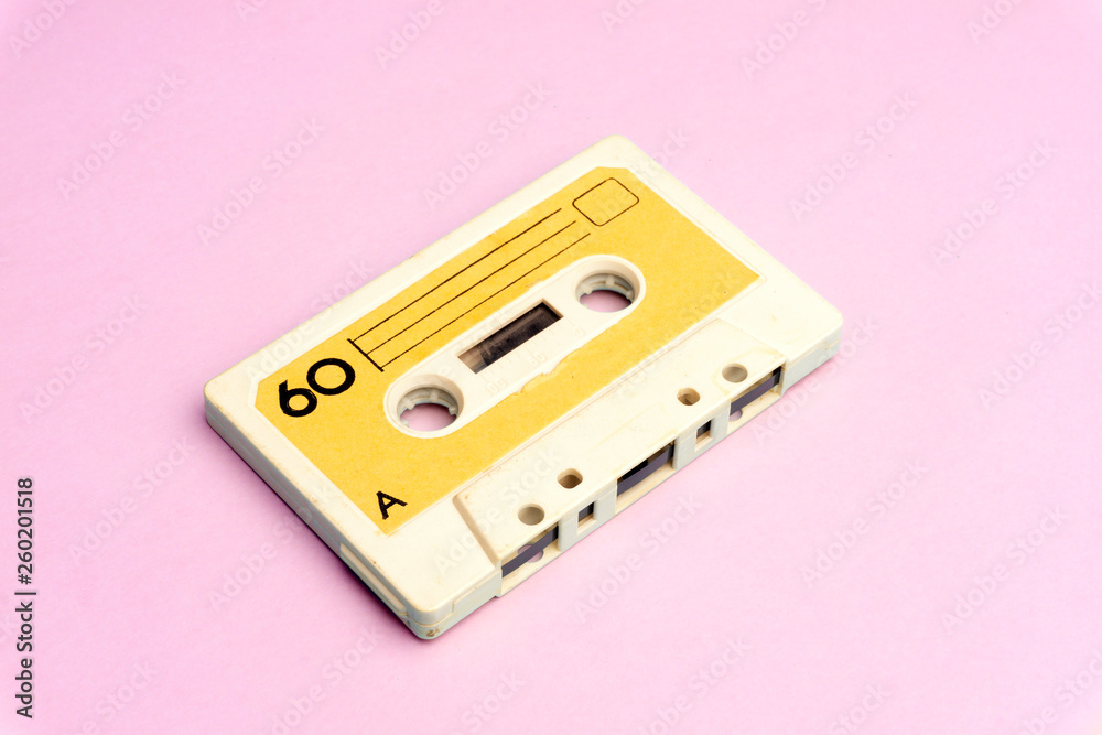 Obraz premium Retro old school 80-s or 90-s concept. Audio cassette on a bright blue-pink background