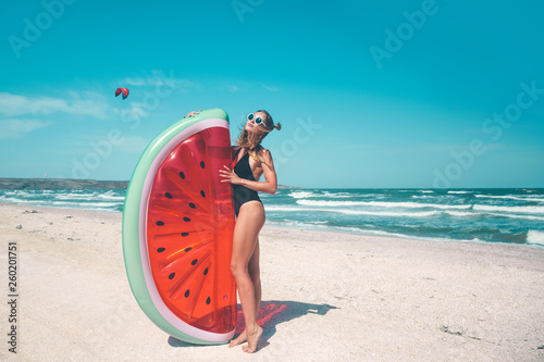 Model with watermelon lilo at the beach