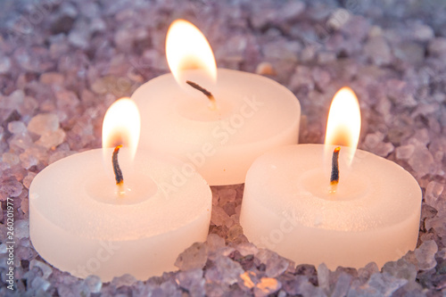 preparations for the bath and aromatherapy : three decorative candle stand in aromatic sea salt with smell of lavender, close