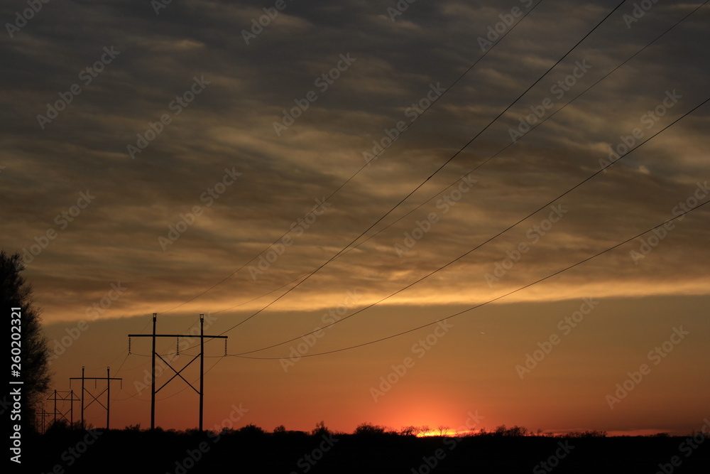 Kansas Sunset with power lines and poles.